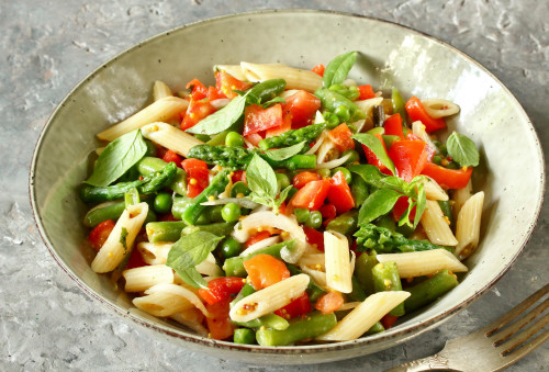 Pasta penne met groene asperges, sperziebonen, doperwten, tomaten en basilicum