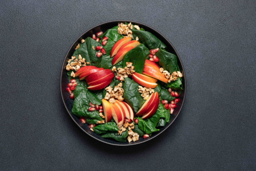 Salade met spinazie, appel, granaatappel en walnoten