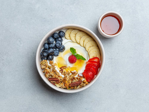 Plantaardige yoghurtbowl met blauwe bessen, aardbei, banaan, agavesiroop & granola