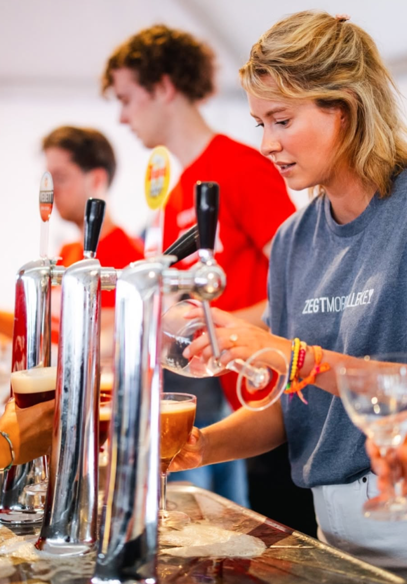 Foto van Antwerps burgemeester Els Van Doesburg die een Bolleke (bier) tapt op de Bollekesfeesten in Antwerpen